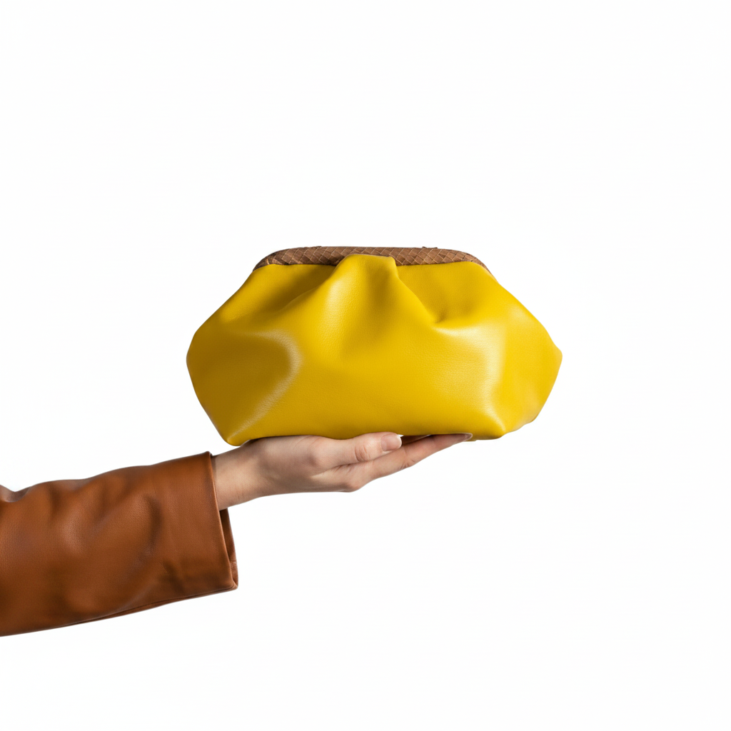Mano e borsa gialla sfondo bianco
